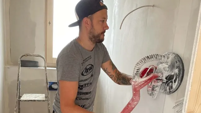 Zugeschneite Schlittenwiese mit spielenden Kindern und einer großen Figur aus Stroh