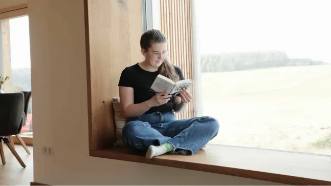 Zugeschneite Schlittenwiese mit spielenden Kindern und einer großen Figur aus Stroh