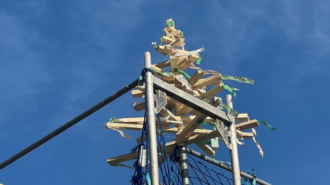 Aus Holzstäben gebauter Tannenbaum auf einem Metallpfosten mit Blauen Himmel Hintergrund